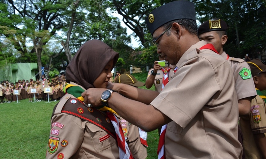 Kak Deny menyematkan tanda peserta kegiatan bina muda