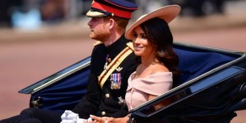 Gaya busana Meghan Merkle mengenakan gaun off shoulder.